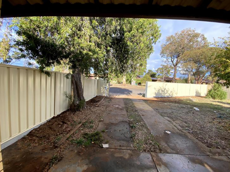 Cream steel fence along a driveway, seen from under a carport